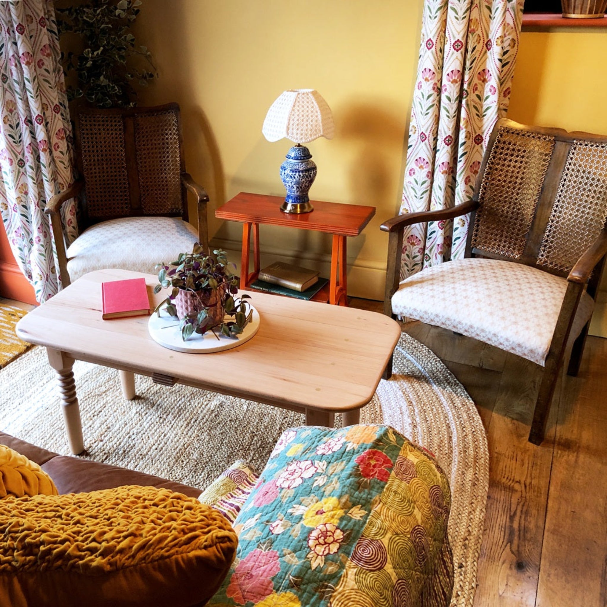 Living room with wooden coffee table, chairs, and decorative items.