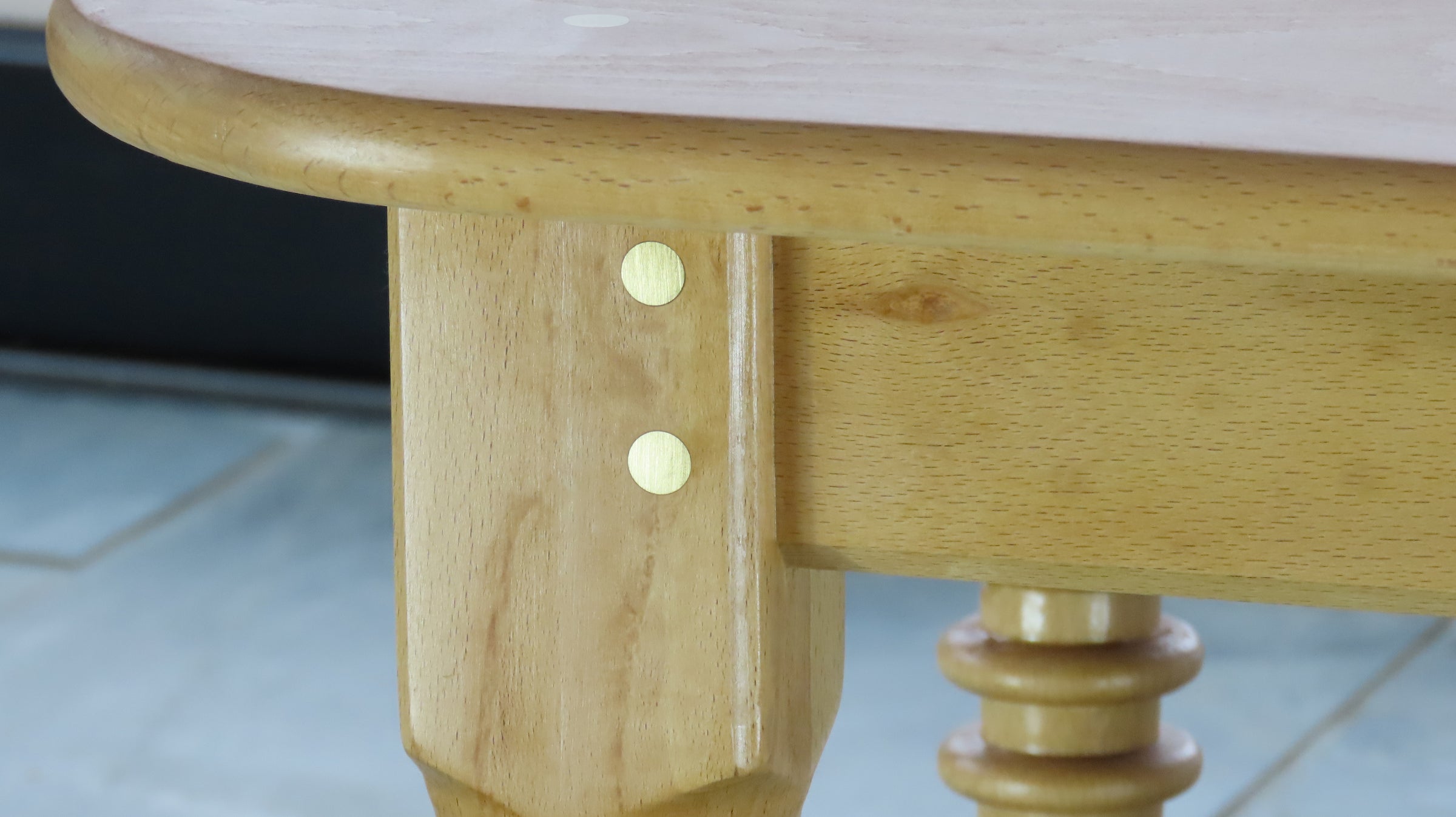 Close-up of Cityfarm seat table leg showing brass dowels and handcrafted hardwood detail