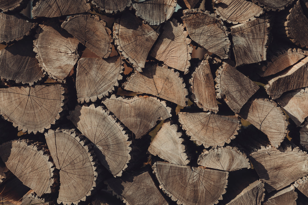 Neatly stacked firewood arranged in a geometric pattern, showcasing natural wood textures and warm tones