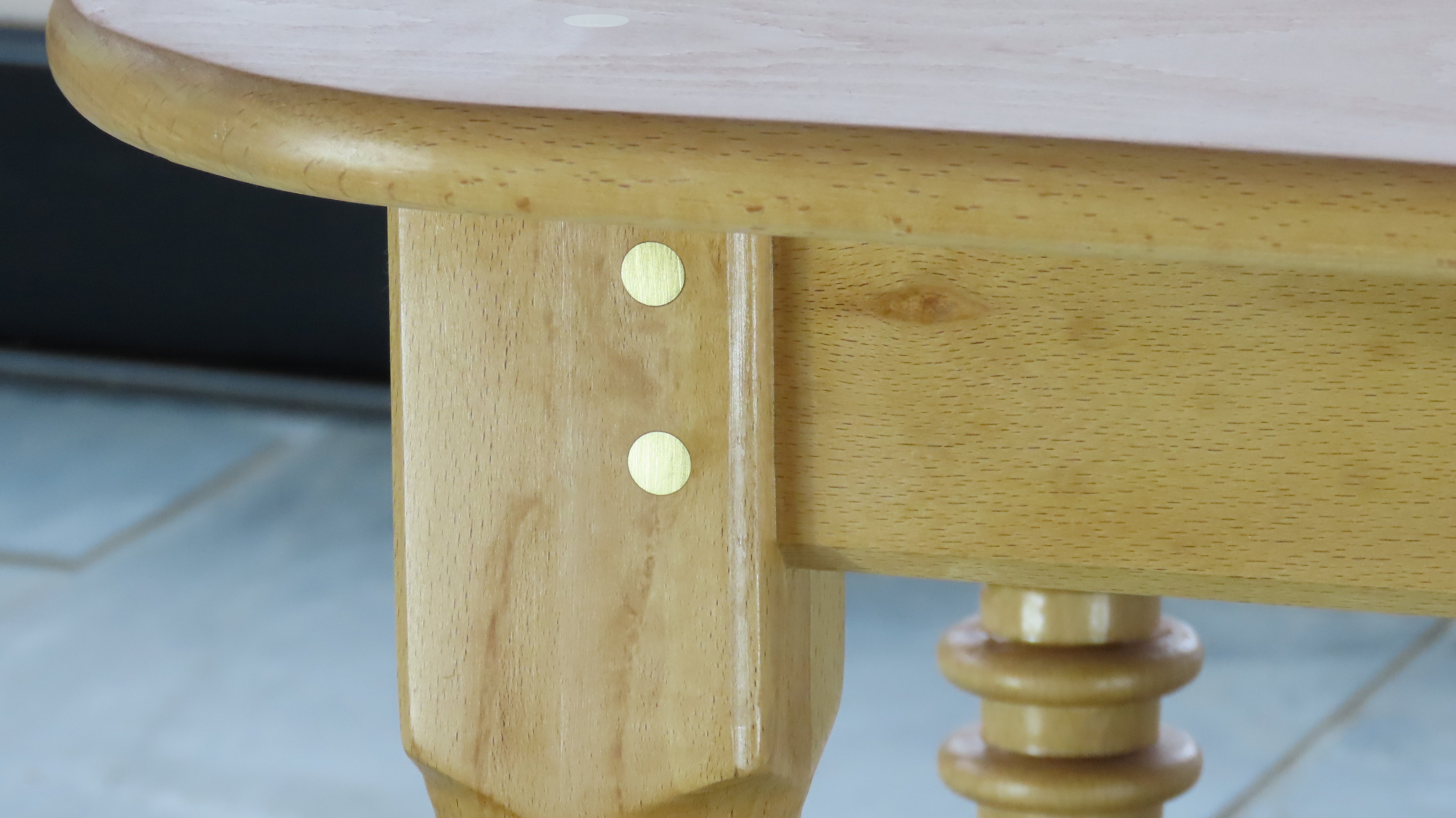 Close-up of Cityfarm seat table leg showing brass dowels and handcrafted hardwood detail