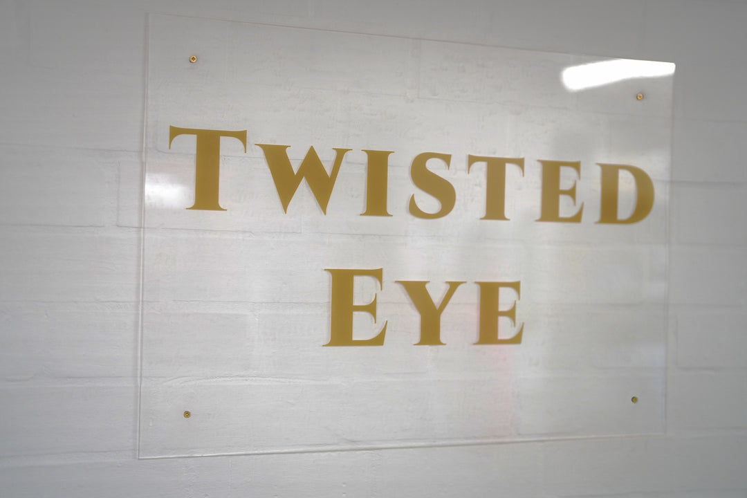 Gold 'TWISTED EYE' text on a white background